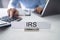 IRS Nameplate In Front Of Accountant Calculating Tax