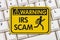 IRS scam warning sign with keyboard