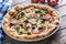 Irtalian pizza with broccoli spinach tomatoes olives and mozzarela or parmesan cheese. Mediterranean vegetarian meal