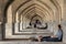 ISFAHAN, IRAN - AUGUST 20, 2016 : Iranian people resting under the arches of Khaju bridge, in Isfahan, in the warmer hours of summ