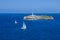 Isla de Mouro island in Santander, Cantabria, Spain. Sailing boat in the bay. Two sailboats and lighthouse