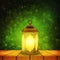 Islamic lantern on wooden table and emerald night background with bokeh for Muslim Community festival. Bright beautiful