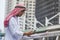 Islamic man using smartphones app organize schedule agenda  focus on hands holding smartphone muslim modern uae city. Arab men