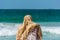 A Islamic woman wearing hijab and watching the waves,  water splash flushing beach at Jumeirah beach at Persian gulf in Dubai,
