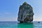 An island in the Andaman Sea. Over the aquamarine water rise the steep rocky slopes of a small uninhabited island.