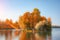 Island with autumn sloping trees in a large lake