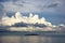 Island in the black sea over which gathered Cumulus clouds