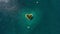 Island in the form of heart in the ocean and flying plane