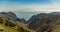 Island of La Gomera, soaring over the horizon, partly covered by the clouds. Bright blue sky. View from 1900 meters of altitude.