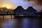 Island in ocean, overwater villas at the time sunset.