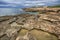 Island scenery with rocks and sea in gloomy weather, lighthouse