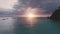 Island silhouette at colorful sunrise aerial. Sailboats on sea bay. Summer nobody nature seascape