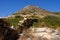 Island of Syros in greece, panorama of cliff close to Varvarousa beach with sand land and sea. Dry land. Typical rocky dry walls.