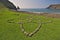 Isle of Skye, Scotland - Stones arranged in the shape of a flower on green grass with Talisker Bay in the background