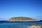 Islet of cala conta dipped in the blue of the tourist sea of â€‹â€‹ibiza in summer