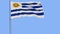 Isolate flag of Uruguay on a flagpole fluttering in the wind on a blue background