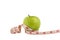 Isolate green apple on white bakcground with Measuring tape around. The heathy fruit for people who want to increase health up.