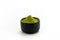 Isolate Heap Green Tea Powder in black ceramic bowl. Extract Tea Leaves in dark stone cup.