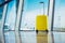 Isolate traveler tourist yellow suitcase at floor airport on background large window, bright luggage waiting in departure lounge