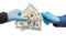 Isolated 2 hands in medical gloves with dolars and hryvnias on a white background. The concept of corruption or quarantine, give o