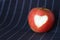 An isolated apple with a carved heart. on a dark background. copyspace for text