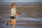 Isolated background portrait of young happy and attractive fit woman running on the beach in outdoors jogging workout in fitness t