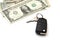 Isolated black car key and a bunch of banknotes of American dollars