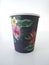 Isolated black takeaway disposable cup painted with Caribbean flowers on white background