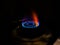 Isolated blue flame with orange shade of gas burner at black background