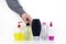 Isolated bottles of detergents on a white background. The hand takes the jars of detergents. In the photo, shampoo, micellar water