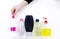 Isolated bottles of detergents on a white background. The hand takes the jars of detergents. In the photo, shampoo, micellar water