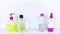 Isolated bottles of detergents on a white background. The hand takes the jars of detergents. In the photo, shampoo, micellar water