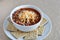 Isolated bowl of chilli soup with cheese and whole wheat saltine crackers.