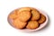 Isolated bunch of round biscuits with sesame on a light pink plate on a white background.