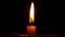 An isolated burning candle flame on a black background