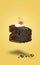 Isolated chocolate cherry cake flying on yellow background