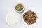 Isolated close up flat lay top view shot of a bowl of sliced beef fillet pieces, a plate of cellophane glass noodles and a cup of