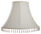Isolated close up shot of a classic cut corner bell shaped white tapered lampshade with a beaded fringe on a white  background