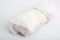 Isolated close up shot of a sandwich wrapped in a baking paper wrap package with a green ribbon, on a white background