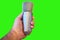 Isolated closeup of a man\'s hand holding a condenser microphone on a green background