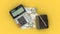 isolated composition of Colombian Peso notes, a calculator, a note book and a pen