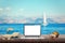 Isolated display of laptop on wooden table for mockup. Sea, yacht and blue sky in background.