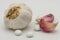 Isolated, dried Garlic bulb together with a pair of Garlic cloves seen together with a mock-up of Garlic Health Tablets.