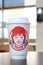 Isolated drinking cup at a Wendy\\\'s restaurant. Out of focus restaurant interior in background.