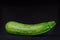 ISOLATED FRESH ZUCCHINI ON DARK CHALK BACKGROUND