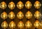 Isolated group of yellow gold shining retro classical light bulbs in rows with glowing filaments and black background