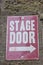 Isolated grungy stage door sign on stone wall