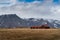 Isolated house in a dramatic landscape of Icelandic typical nature with high and sharp mountains and long flat lands