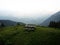 Isolated idyllic remote wooden picnic table bench on green grass hill outdoor nature alpine mountain landscape alps