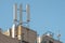 Isolated image of 5G and wireless communications mast seen atop a private office roof.